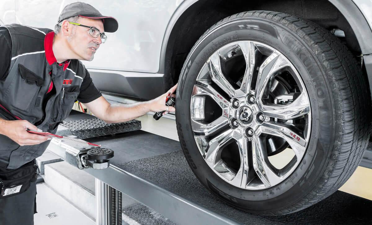 Änderungsabnahme bei GTÜ Neidhardt Ein Mechaniker von GTÜ Neidhardt inspiziert mit einem Messgerät die Räder-Reifen-Komnbination im Rahmen einer Änderungsabnahme.