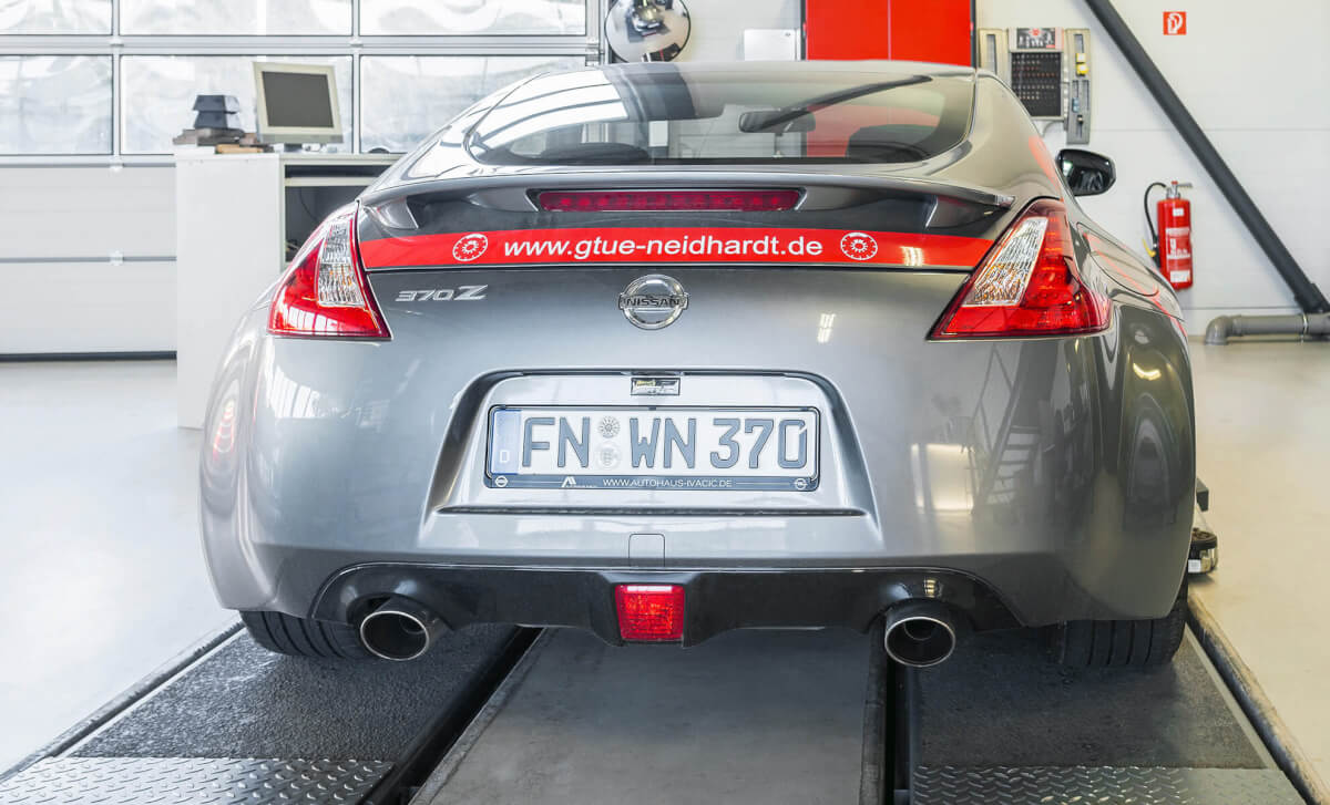 Sportwagen auf Hebebühne Heckansicht eines silbernen Nissan 370Z Sportwagens, der bei GTÜ Neidhardt auf einer Hebebühne steht.