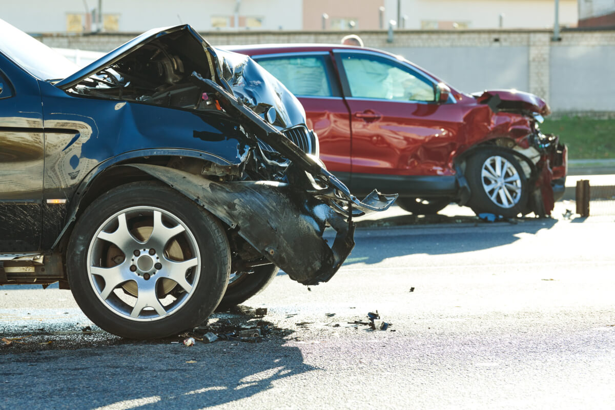 Zwei Autos mit schweren Frontschäden nach einem Auffahrunfall stehen auf der Straße.