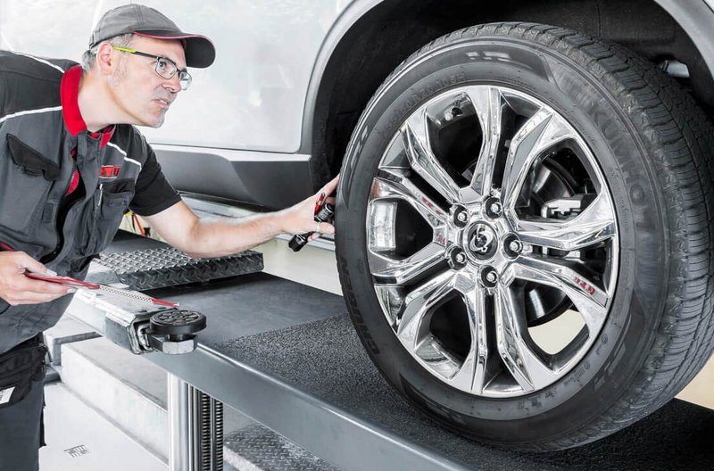Änderungsabnahme bei GTÜ Neidhardt Ein Mechaniker von GTÜ Neidhardt inspiziert mit einem Messgerät die Räder-Reifen-Komnbination im Rahmen einer Änderungsabnahme.
